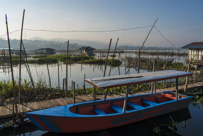 Boats moored in lake against sky