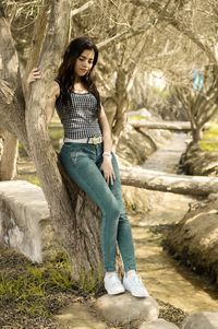 Young woman sitting on tree trunk