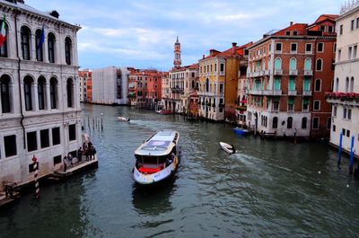 Boats in canal amidst buildings in city