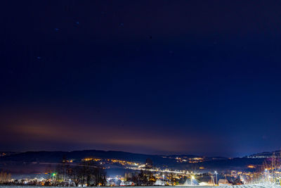 Aerial view of illuminated cityscape against sky at night