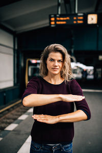 Portrait of beautiful woman standing against car
