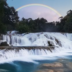 Scenic view of waterfall against sky