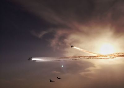 Low angle view of airplane against sky during sunset