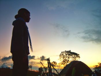 Silhouette man standing against sky during sunset