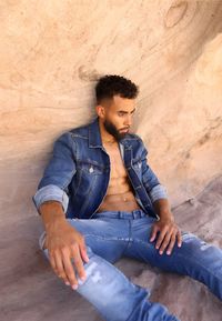 Portrait of young man standing against wall