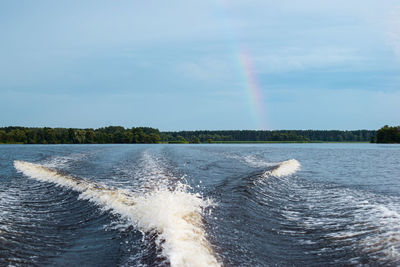 Scenic view of rainbow over sea against sky