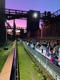 People on railroad tracks in city at night