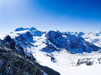 Scenic view of snowcapped mountains against clear blue sky