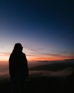 Rear view of silhouette man looking at sunset