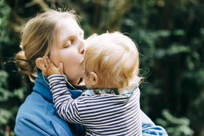 Close-up of mother kissing son