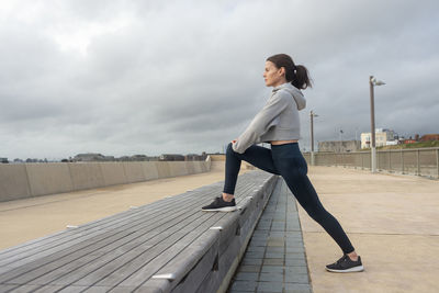 Sporty woman doing leg stretching exercises, outside. outdoor workout.