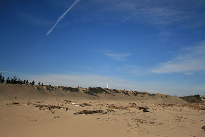 Scenic view of sand dunes against sky