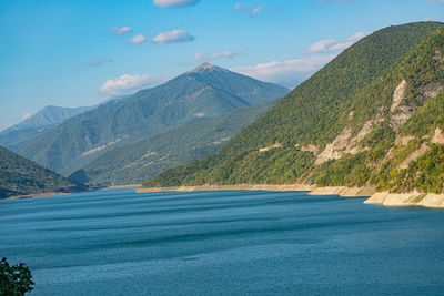 Scenic view of sea and mountains against sky