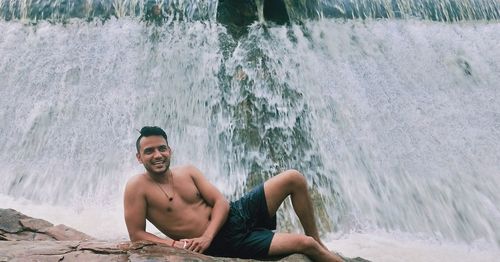 Portrait of young man sitting in sea