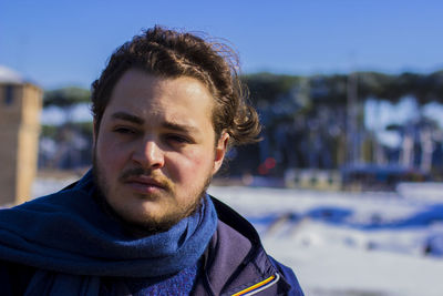 Close-up portrait of woman against blue sky during winter