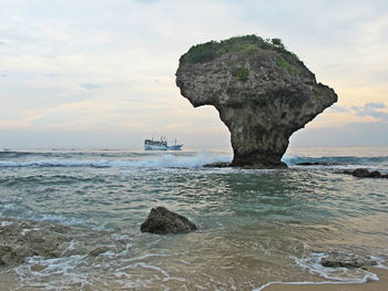 Scenic view of rocks in sea against sky