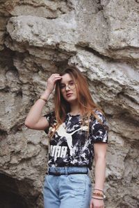 Portrait of young woman standing on rock