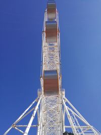 Directly below shot of ferris wheel against clear blue sky