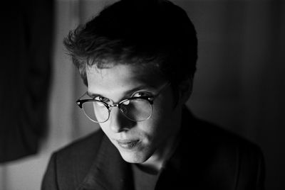 Portrait of businessman wearing eyeglasses in dark room
