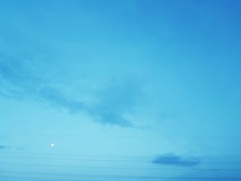 Low angle view of power lines against blue sky