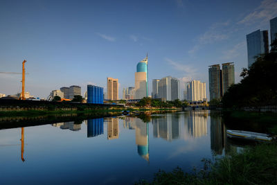 Reflection of buildings in lake against sky