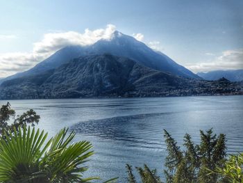 Scenic view of lake by mountains against sky