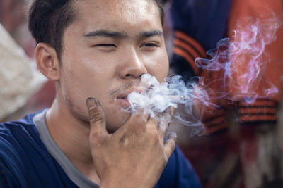 Close-up portrait of man smoking