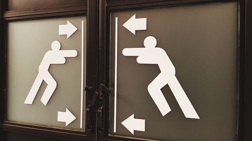 Close-up of arrow sign on door
