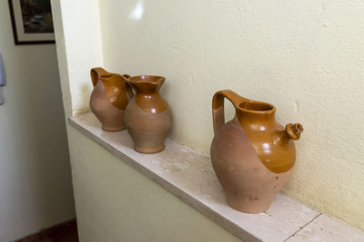 Close-up of old objects on table against wall at home