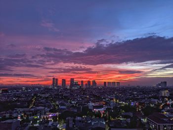 Aerial view of buildings in city during sunset