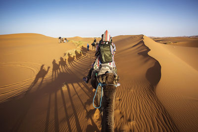 Panoramic view of man riding in desert against sky