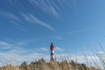 Lighthouse on field against sky