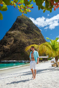 Rear view of woman standing at beach