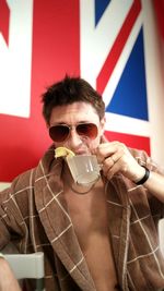 Portrait of young man drinking glass