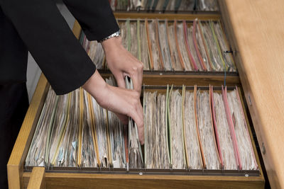 Midsection of businesswoman removing files at office