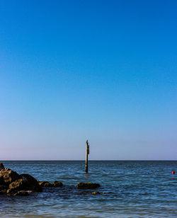 Scenic view of sea against clear blue sky