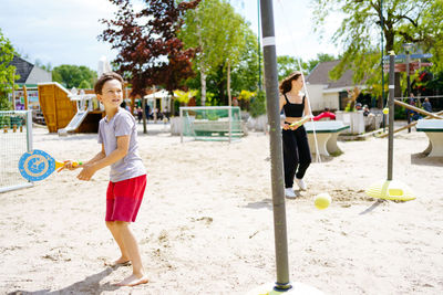 Boy and girl playing beach tennis on the sand on the beach