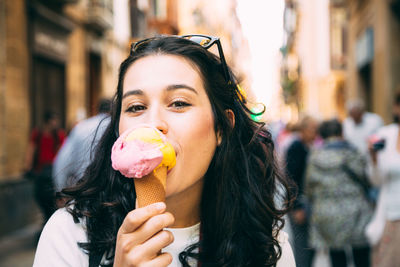 Young woman eating ice cream on street