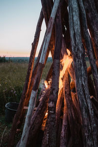 Close-up of wooden log on field against sky