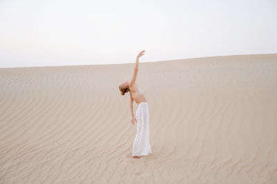 Woman in the desert with arms raised