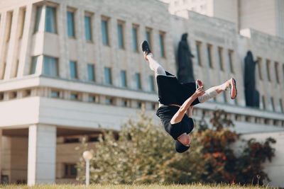 Full length of man jumping against building