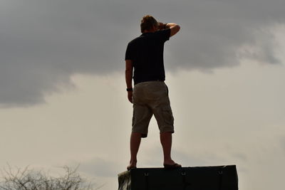 Rear view of man standing against sky