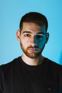 Portrait of young man against blue background