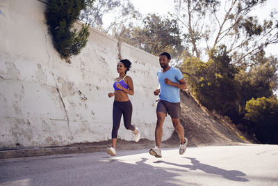 Determined friends jogging on street