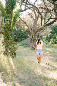 Rear view of woman walking on field