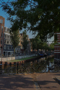 Bicycle by railing against buildings in city