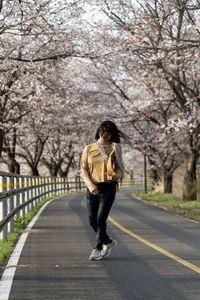 Portrait of young woman walking on road