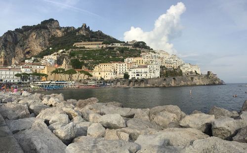 Scenic view of sea by cliff against sky