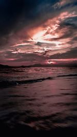 Scenic view of sea against dramatic sky during sunset