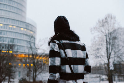 Rear view of woman standing in city in winter